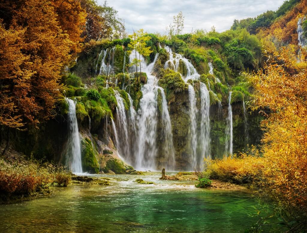 Veliki slap na Plitvičkim jezerima jedan je od najimpresivnijih prizora kada su u pitanju slapovi u Hrvatskoj. Na fotografiji je prikazan u jesen, okružen toplim bojama lišća i snažnim vodenim tokom.